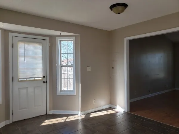 an empty room with wooden floor closet and windows