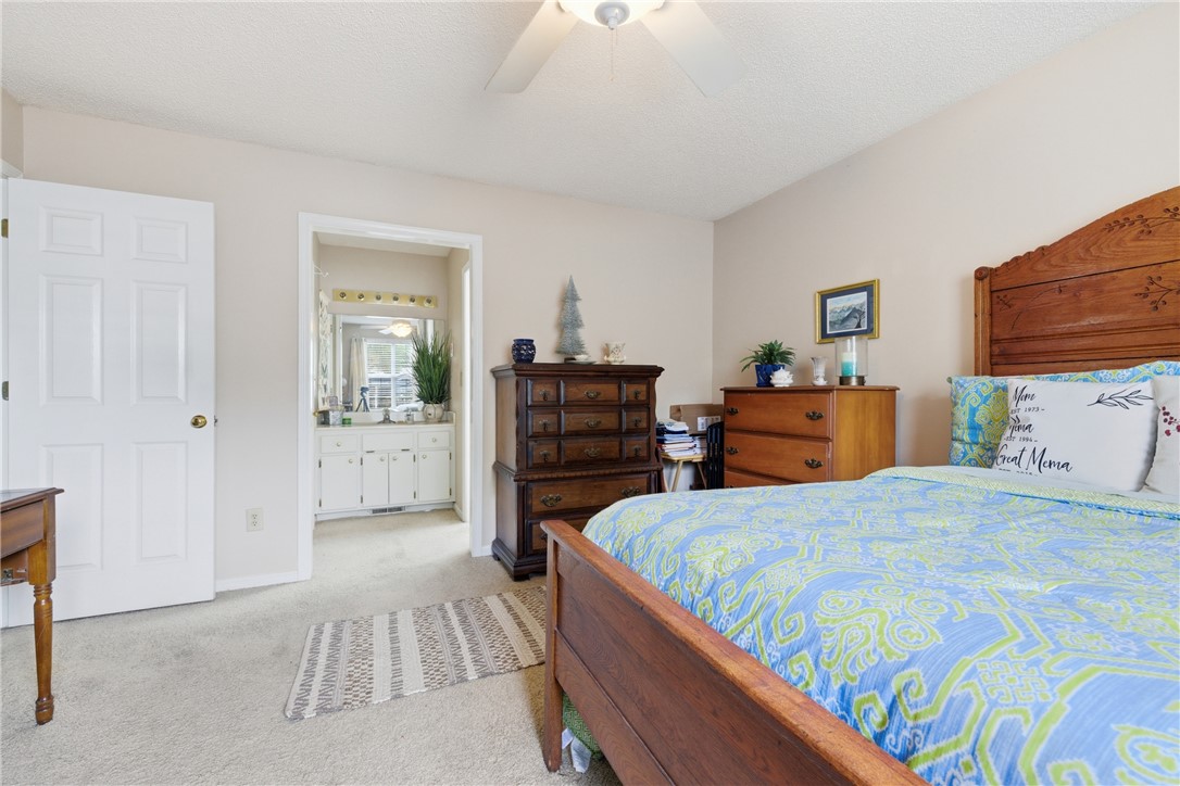 128 Kelly Lane Easley, SC 29642 - Photo 17 of 23 A well-lit bedroom features plush carpeting, leading to a connected bathroom with vanity mirror lighting.