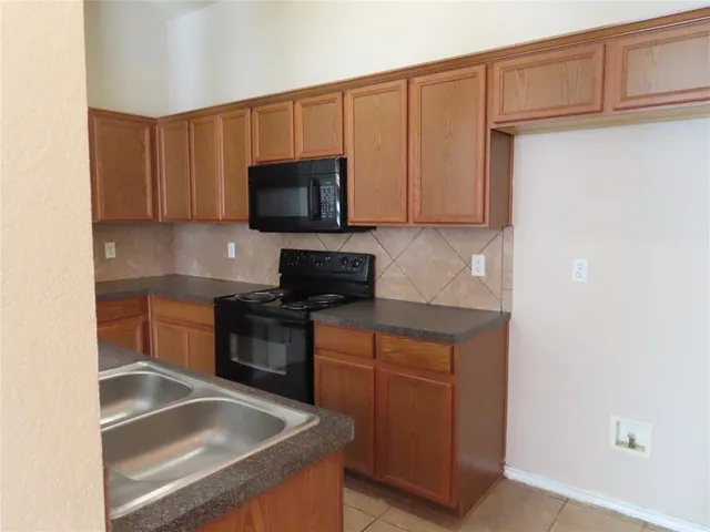 a kitchen with stainless steel appliances granite countertop a sink stove and microwave