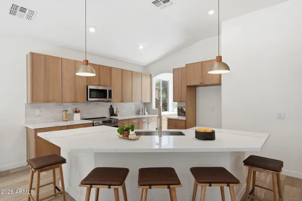 a kitchen with a dining table chairs and white cabinets