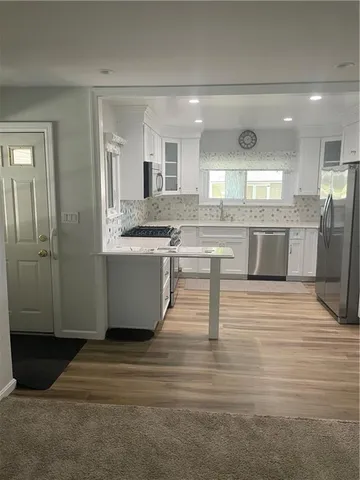 a kitchen with stainless steel appliances granite countertop a stove sink and microwave