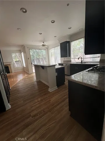 a kitchen with granite countertop a stove and a wooden floor
