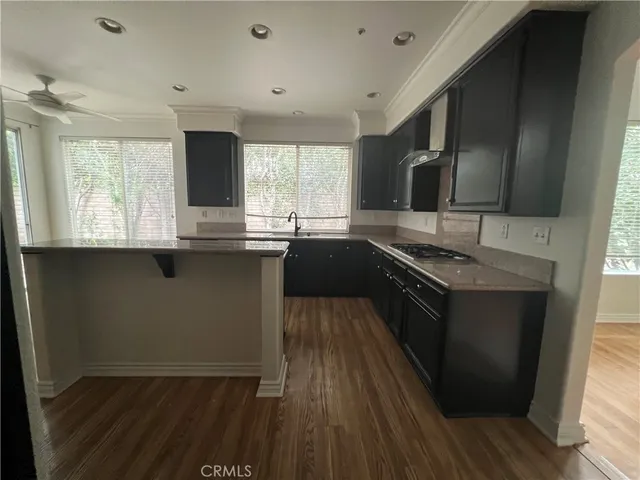 a kitchen with granite countertop a sink stove and cabinets