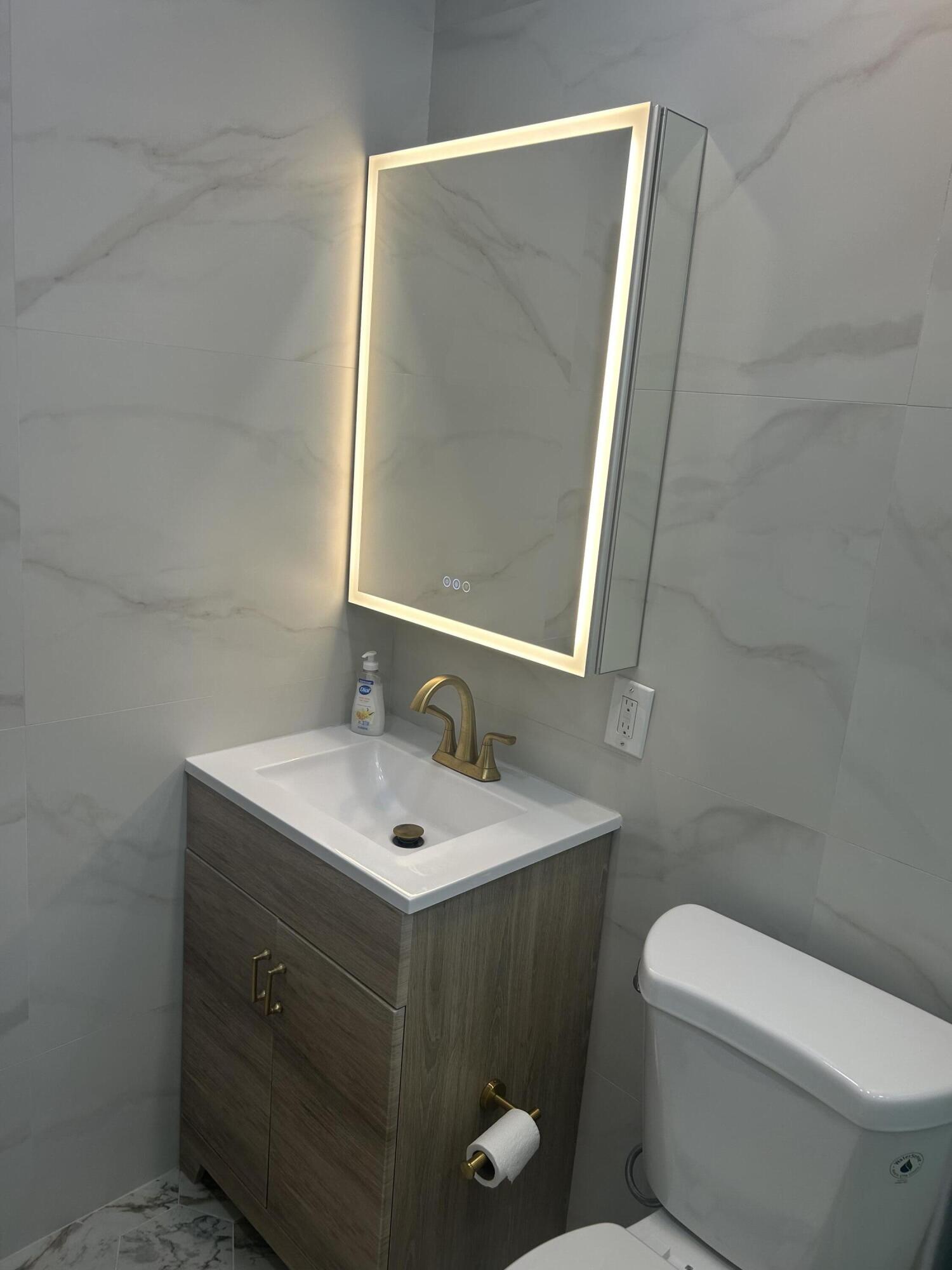 11201 Northeast 3rd Avenue Miami, FL 33161 - Photo 11 of 15 a bathroom with a toilet sink and mirror