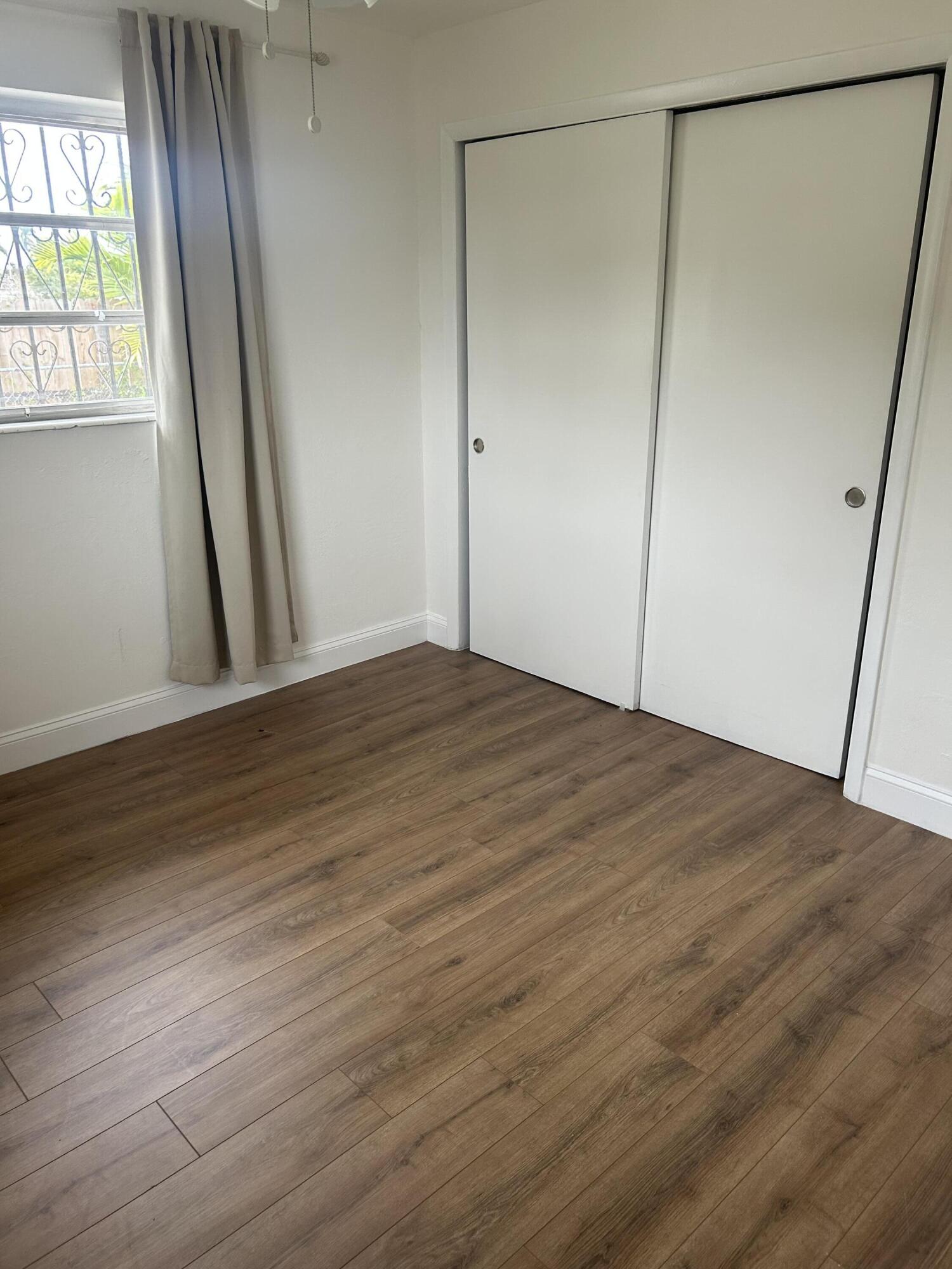 11201 Northeast 3rd Avenue Miami, FL 33161 - Photo 12 of 15 a view of an empty room with wooden floor and a window