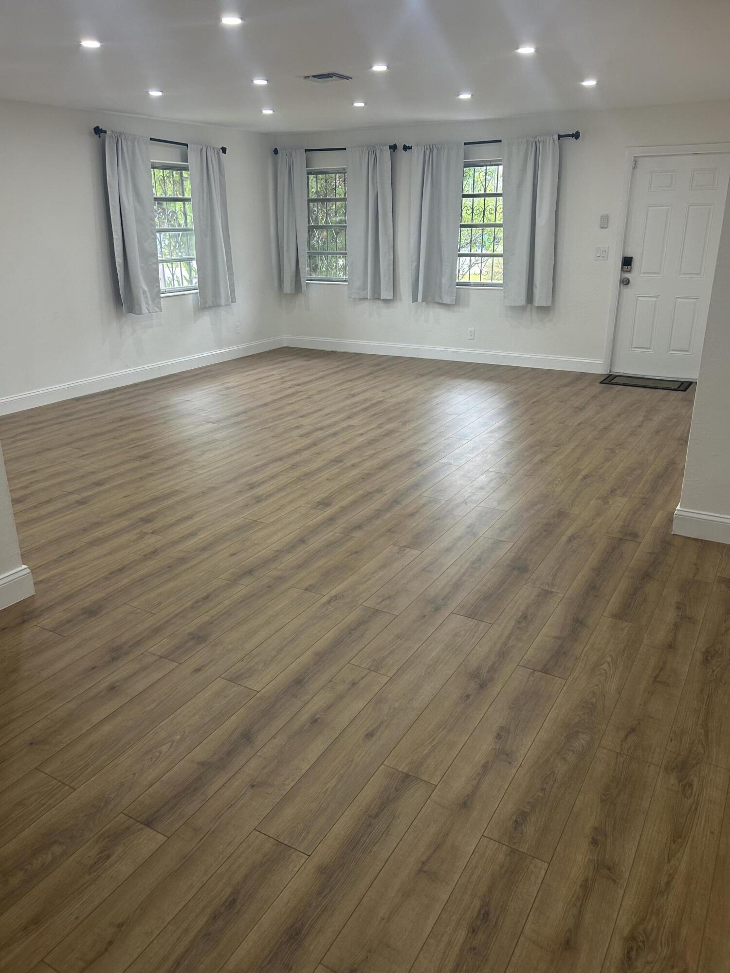11201 Northeast 3rd Avenue Miami, FL 33161 - Photo 3 of 15 an empty room with wooden floor and a window