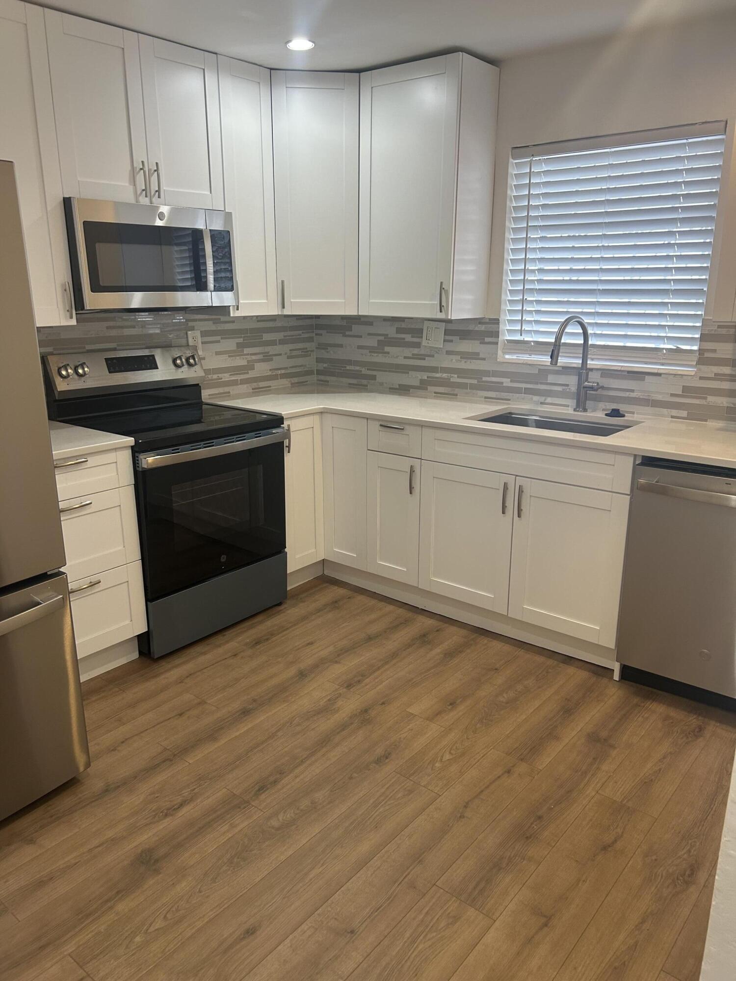 11201 Northeast 3rd Avenue Miami, FL 33161 - Photo 4 of 15 a kitchen with stainless steel appliances granite countertop a stove a sink and a microwave