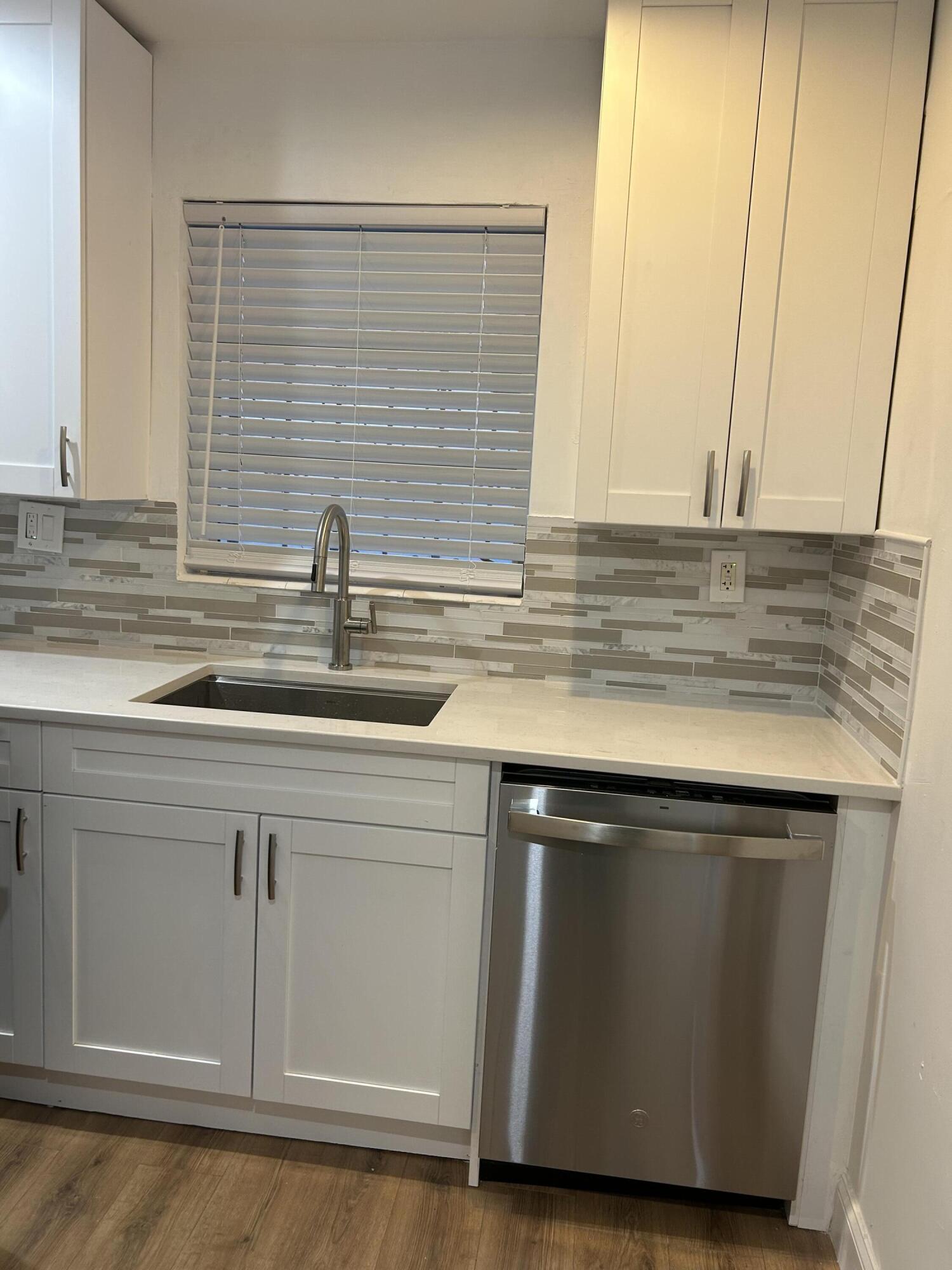 11201 Northeast 3rd Avenue Miami, FL 33161 - Photo 5 of 15 a kitchen with granite countertop cabinets sink and a microwave