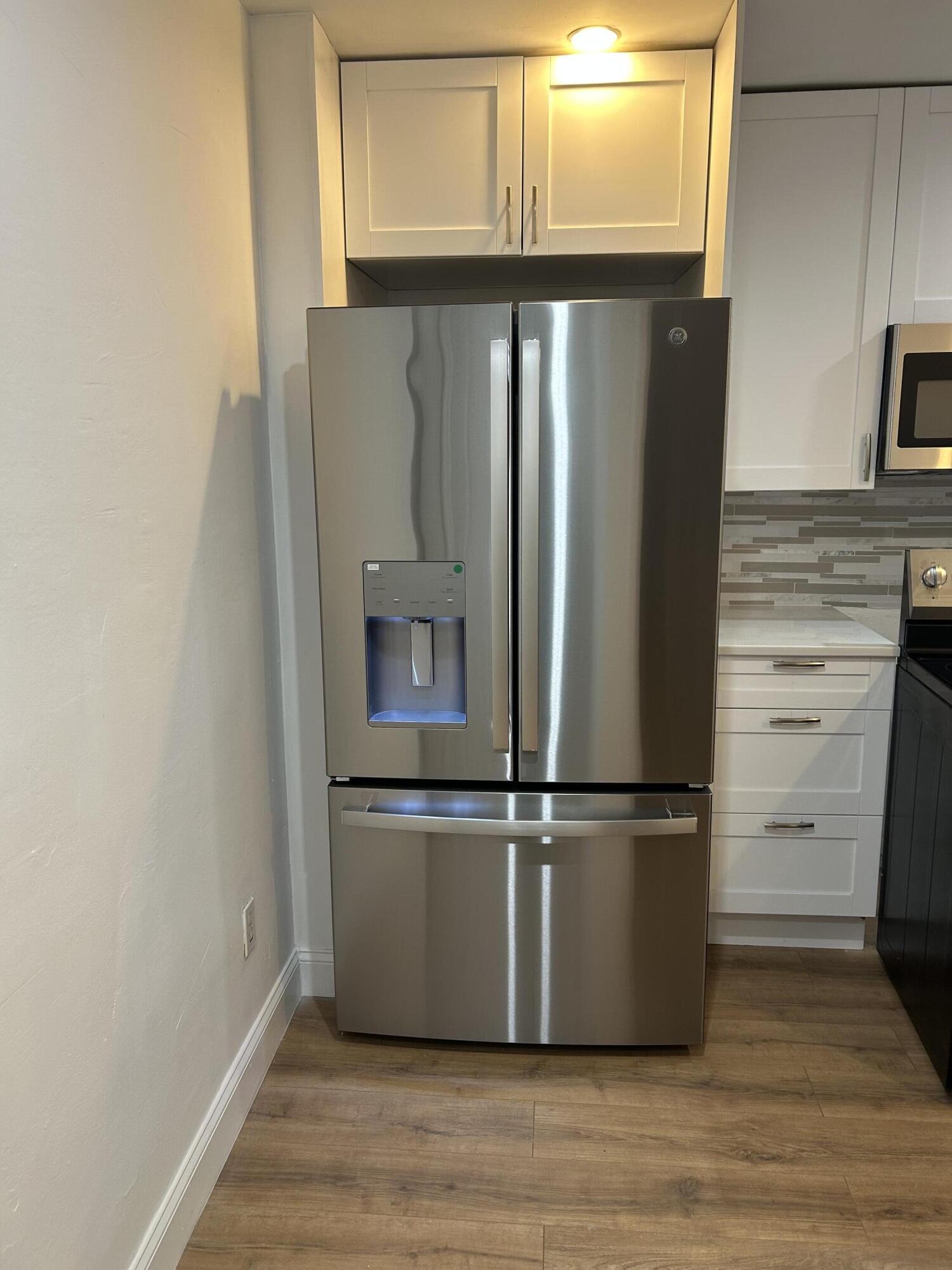 11201 Northeast 3rd Avenue Miami, FL 33161 - Photo 6 of 15 a metallic refrigerator freezer sitting in a kitchen