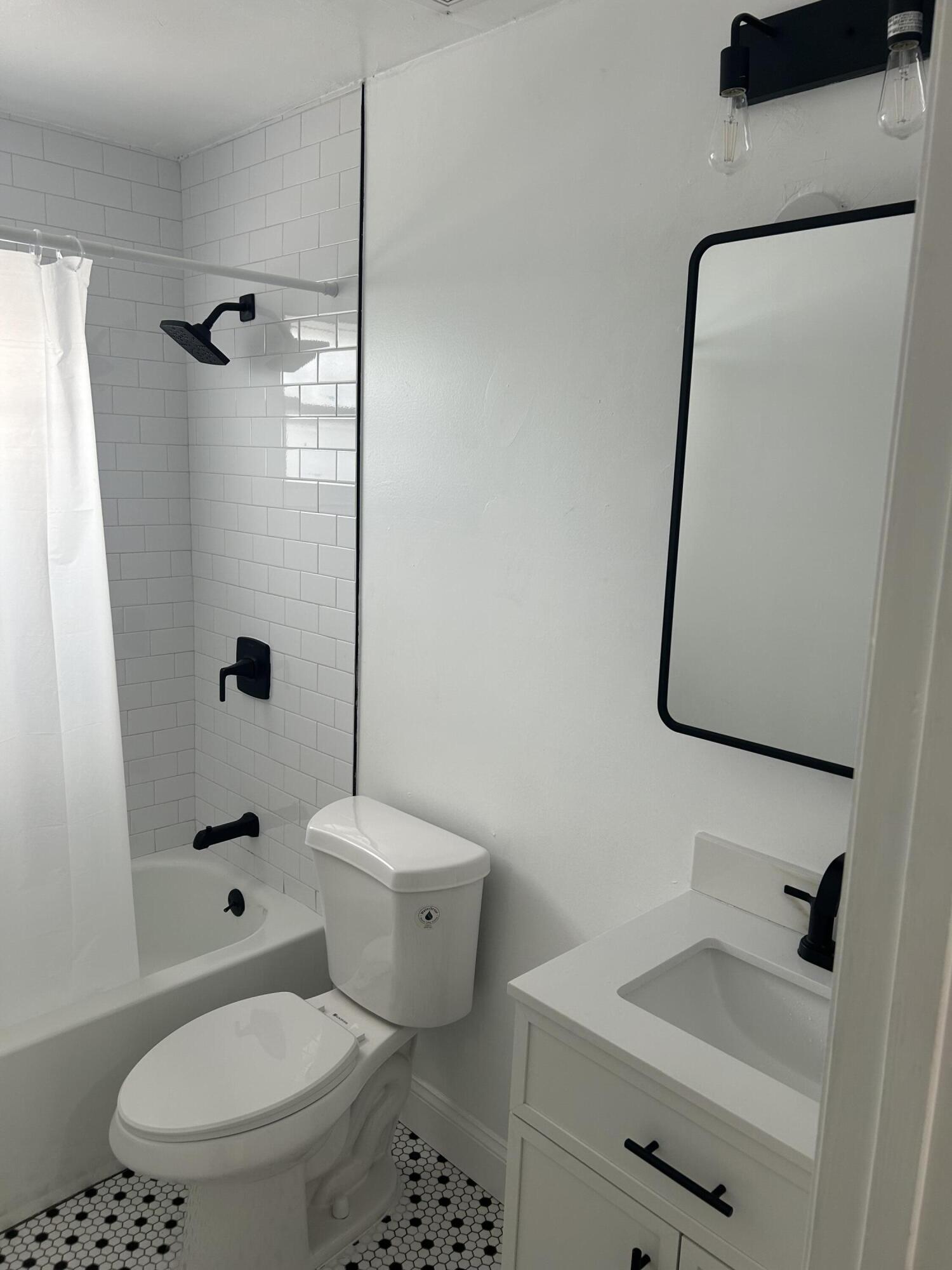 11201 Northeast 3rd Avenue Miami, FL 33161 - Photo 9 of 15 a bathroom with a toilet sink vanity and shower