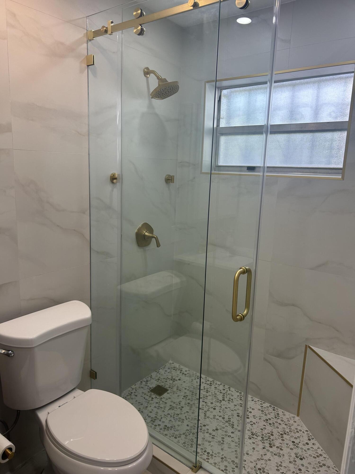 11201 Northeast 3rd Avenue Miami, FL 33161 - Photo 10 of 15 a white toilet next to a shower