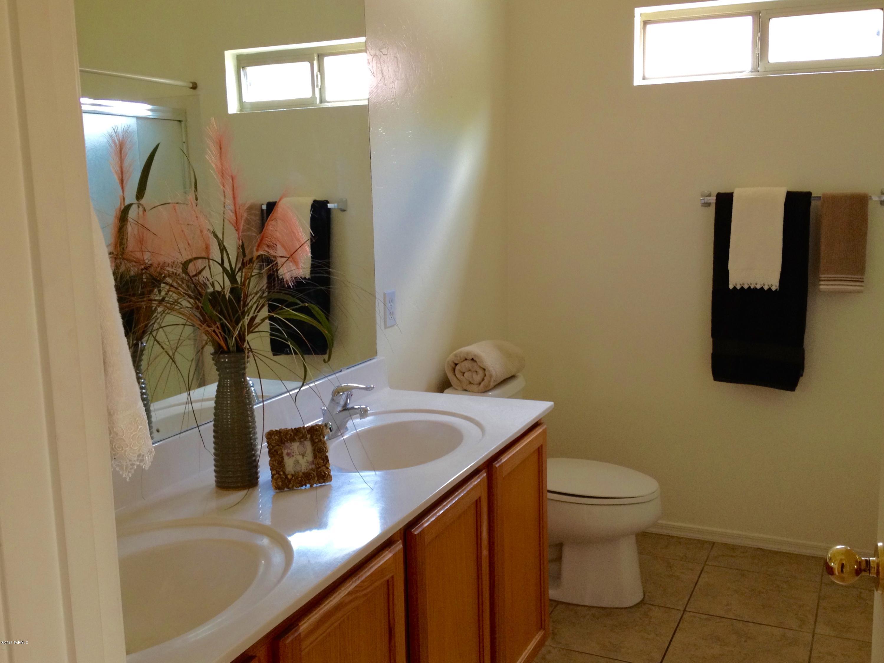 7931 North Iron Ridge Drive Tucson, AZ 85743 - Photo 13 of 21 a bathroom with a sink a toilet and mirror