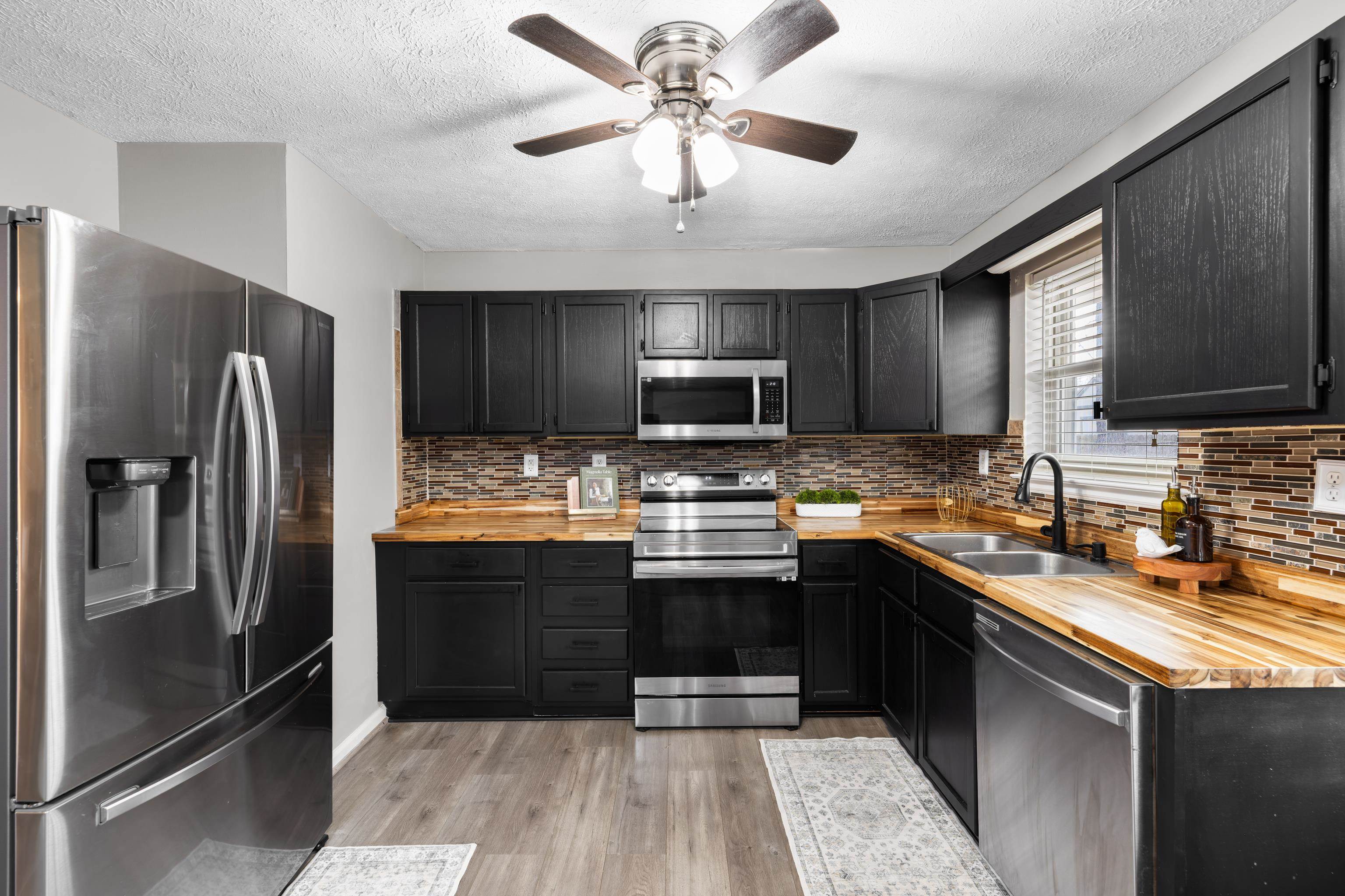77 Greenway Road Stuarts Draft, VA 24477 - Photo 20 of 57 a kitchen with stainless steel appliances granite countertop a refrigerator a sink a stove a microwave and wooden cabinets