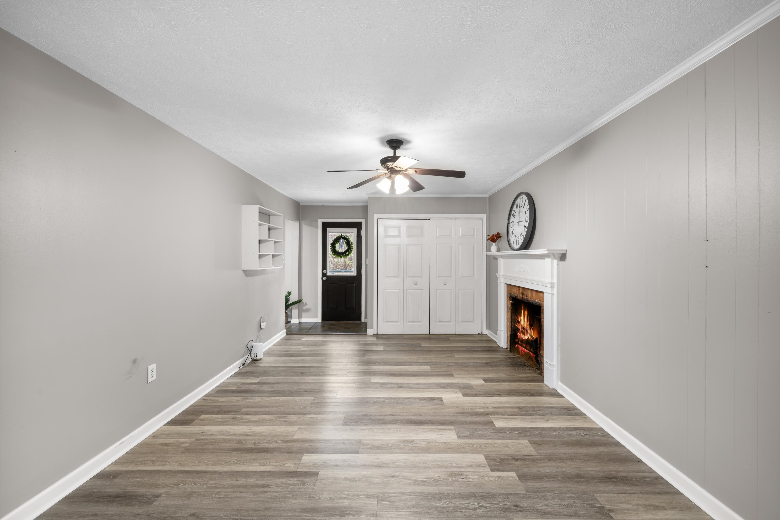 77 Greenway Road Stuarts Draft, VA 24477 - Photo 26 of 57 a view of a livingroom with a fireplace a ceiling fan and wooden floor