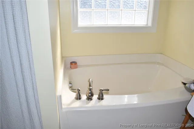 a view of a bedroom with furniture and a ceiling fan