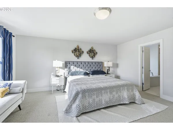 a spacious bedroom with a bed a dresser and chair
