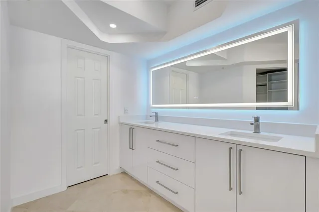 a bedroom with a large bed and a view of walk in closet