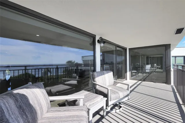 a view of a patio with couches chairs and wooden floor