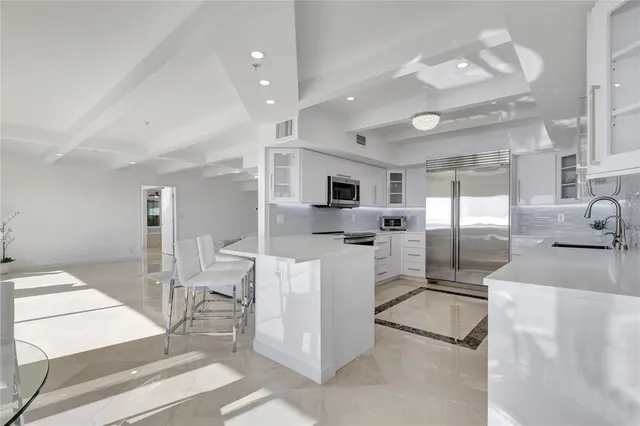 a kitchen with stainless steel appliances kitchen island granite countertop a table and chairs