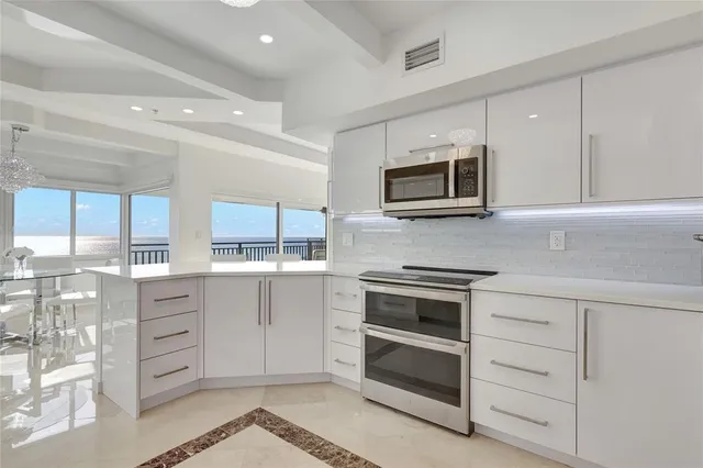 a large white kitchen with a white cabinets and white appliances