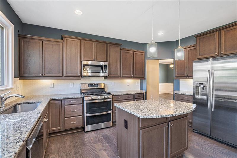 115 Floating Leaf Way Dallas, GA 30132 - Photo 14 of 49 a kitchen with kitchen island granite countertop stainless steel appliances a sink stove refrigerator and cabinets
