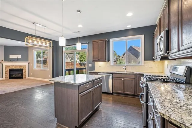 a kitchen with stainless steel appliances granite countertop a stove and a refrigerator
