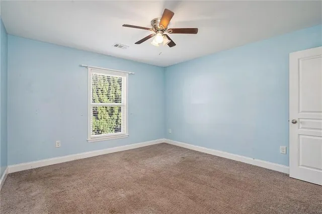 an empty room with windows and fan