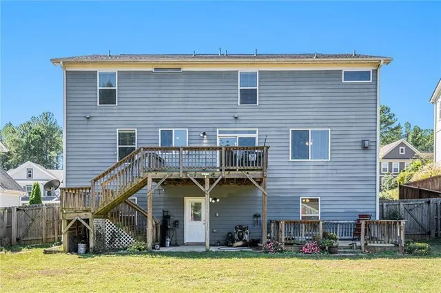 a view of a house with wooden stairs and a small yard