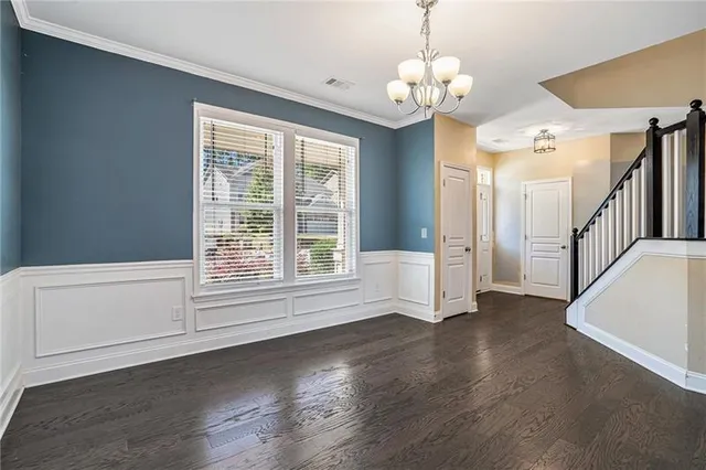a view of a livingroom with wooden floor and a large window