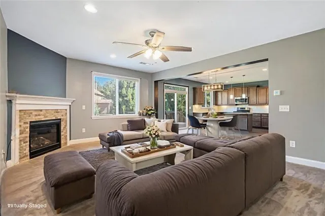 a living room with furniture fireplace and a large window