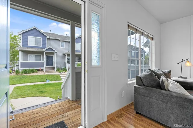 a living room with a couch and a large window with garden view