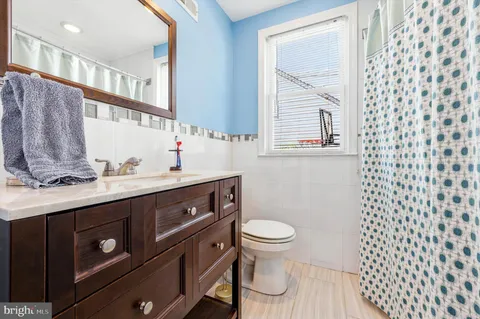 a bathroom with a sink a toilet and a mirror