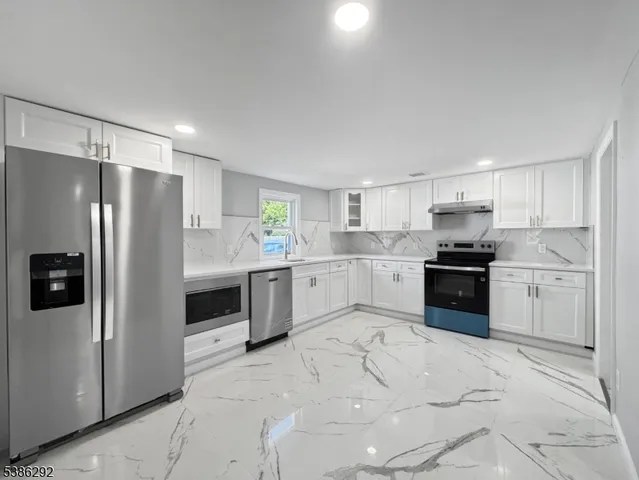 a kitchen with stainless steel appliances a refrigerator sink and cabinets