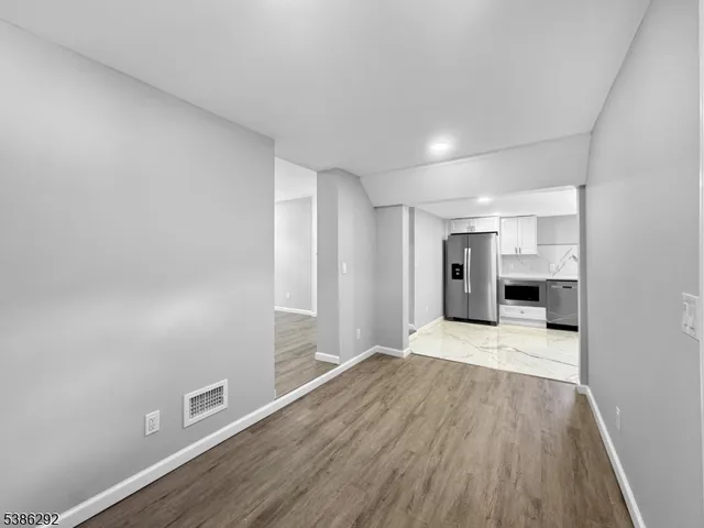 a view of empty room with wooden floor