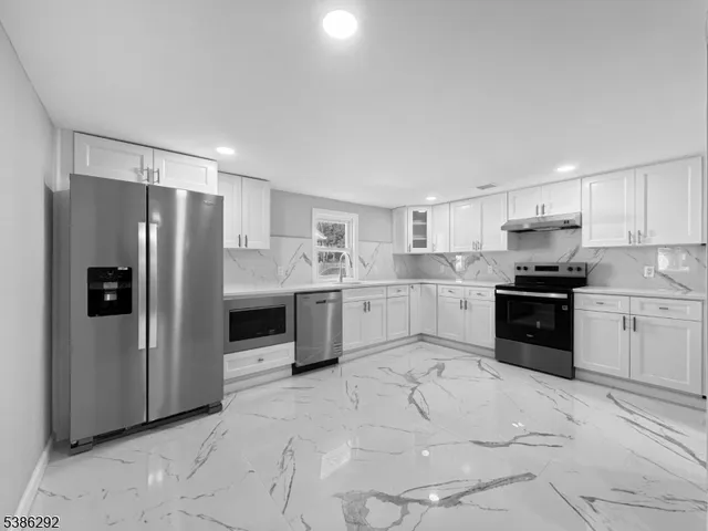 a kitchen with stainless steel appliances a refrigerator sink and cabinets