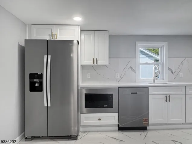 a kitchen with stainless steel appliances a refrigerator sink and cabinets