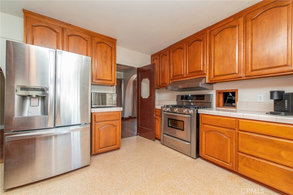 1885 West 9th Street Upland, CA 91786 - Photo 13 of 41 a kitchen with stainless steel appliances granite countertop a refrigerator a stove a sink and dishwasher with a dishwasher
