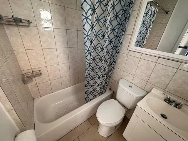a white toilet sitting next to a bath tub