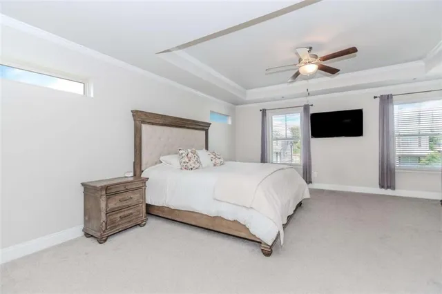 a bedroom with a bed a window and a flat screen tv