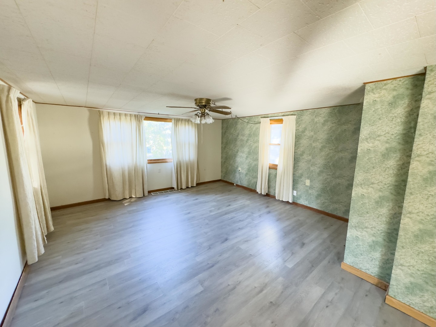 702 East Timber Street Pontiac, IL 61764 - Photo 6 of 24 an empty room with wooden floor and windows