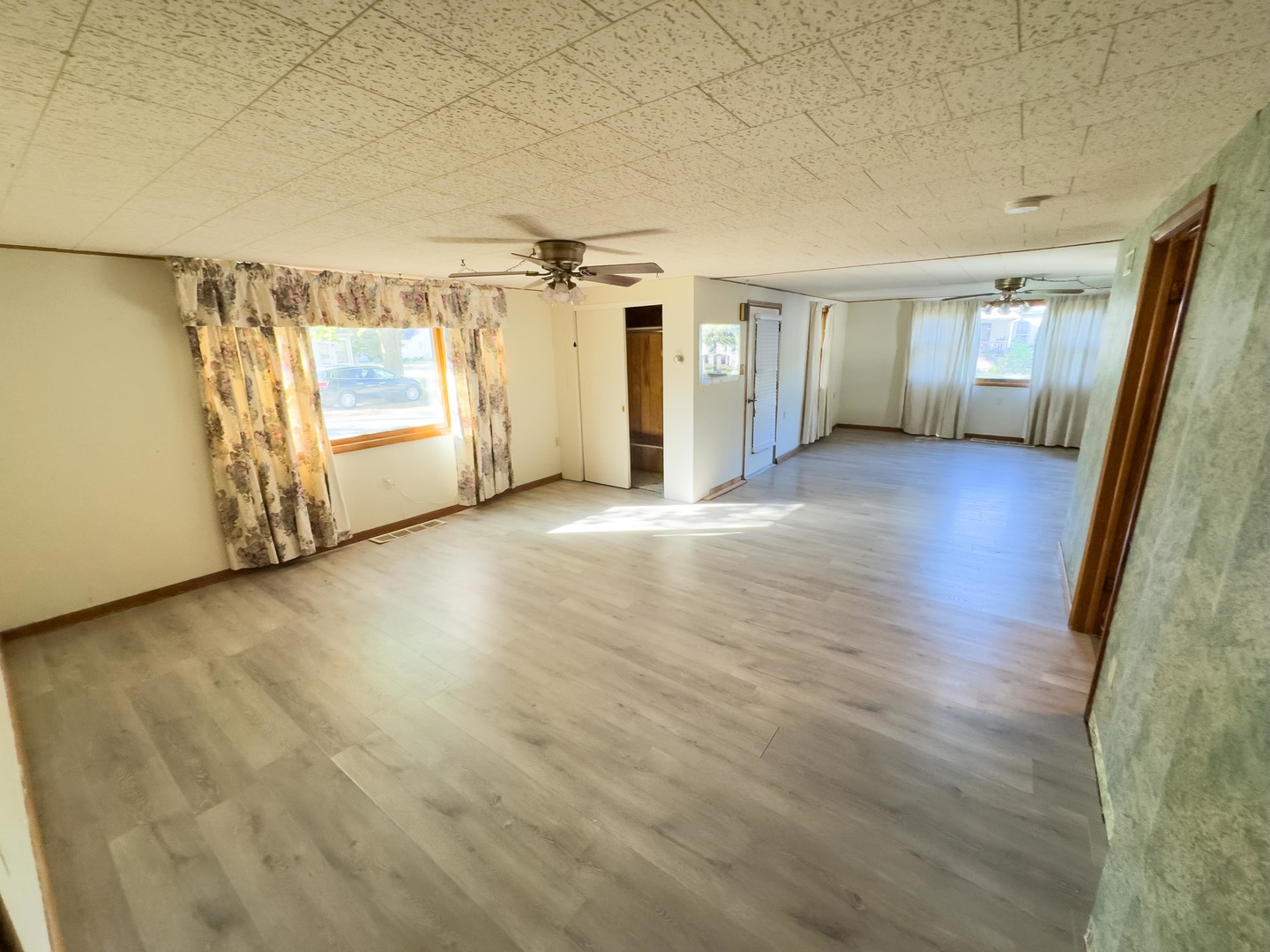 702 East Timber Street Pontiac, IL 61764 - Photo 9 of 24 an empty room with wooden floor and windows
