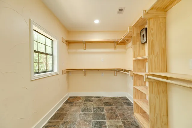 a view of walk in closet with empty racks