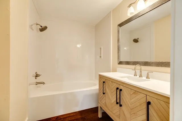 a bathroom with a tub sink and mirror