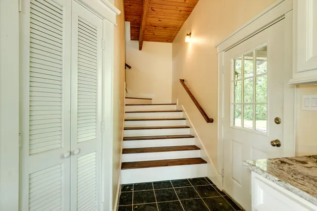 a view of a hallway with wooden floor and windows