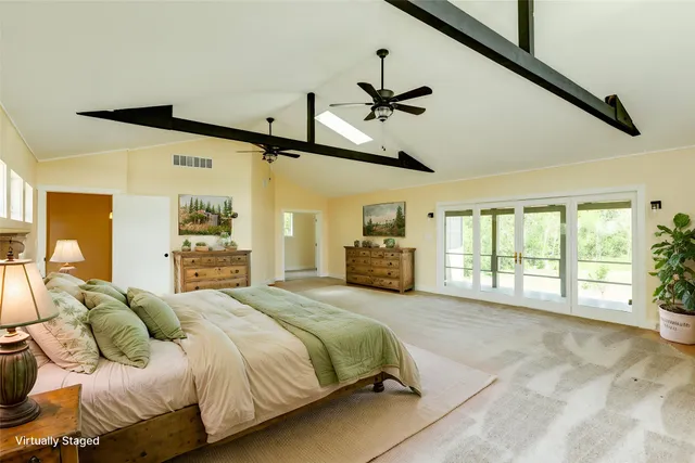 a spacious bedroom with a bed a couch and a large window