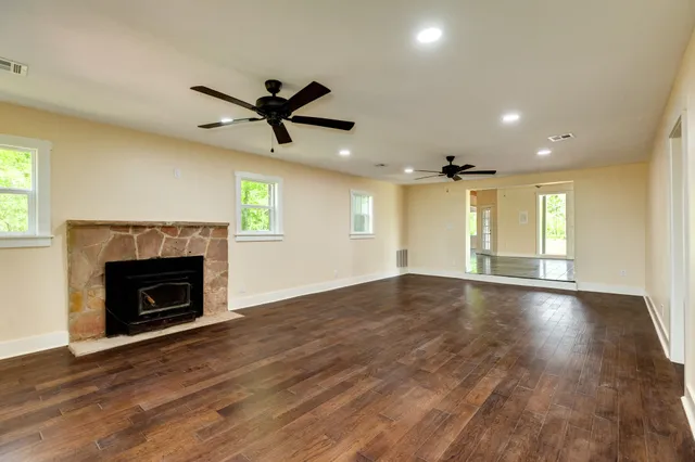 a view of an empty room with a fireplace and a window