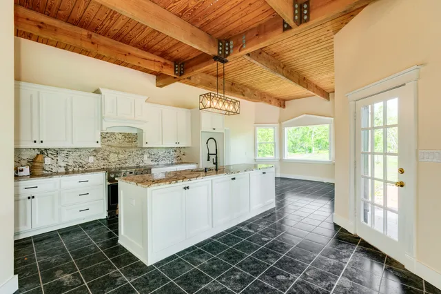 a kitchen that has a lot of cabinets in it and wooden floor