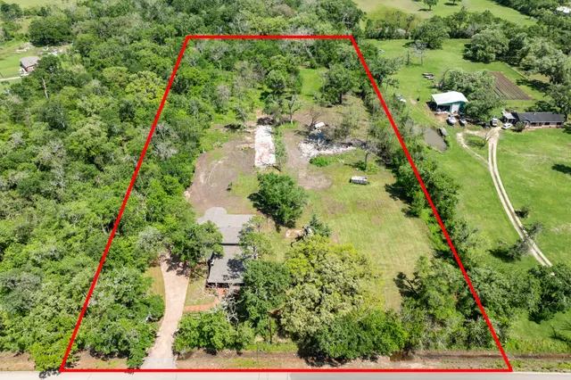 an aerial view of a residential houses with outdoor space and street view