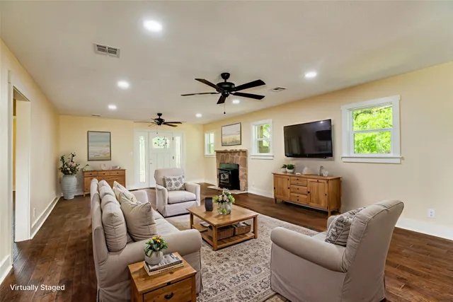 a living room with furniture a flat screen tv and a window