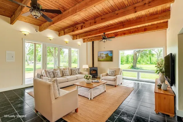a living room with furniture a flat screen tv and a floor to ceiling window